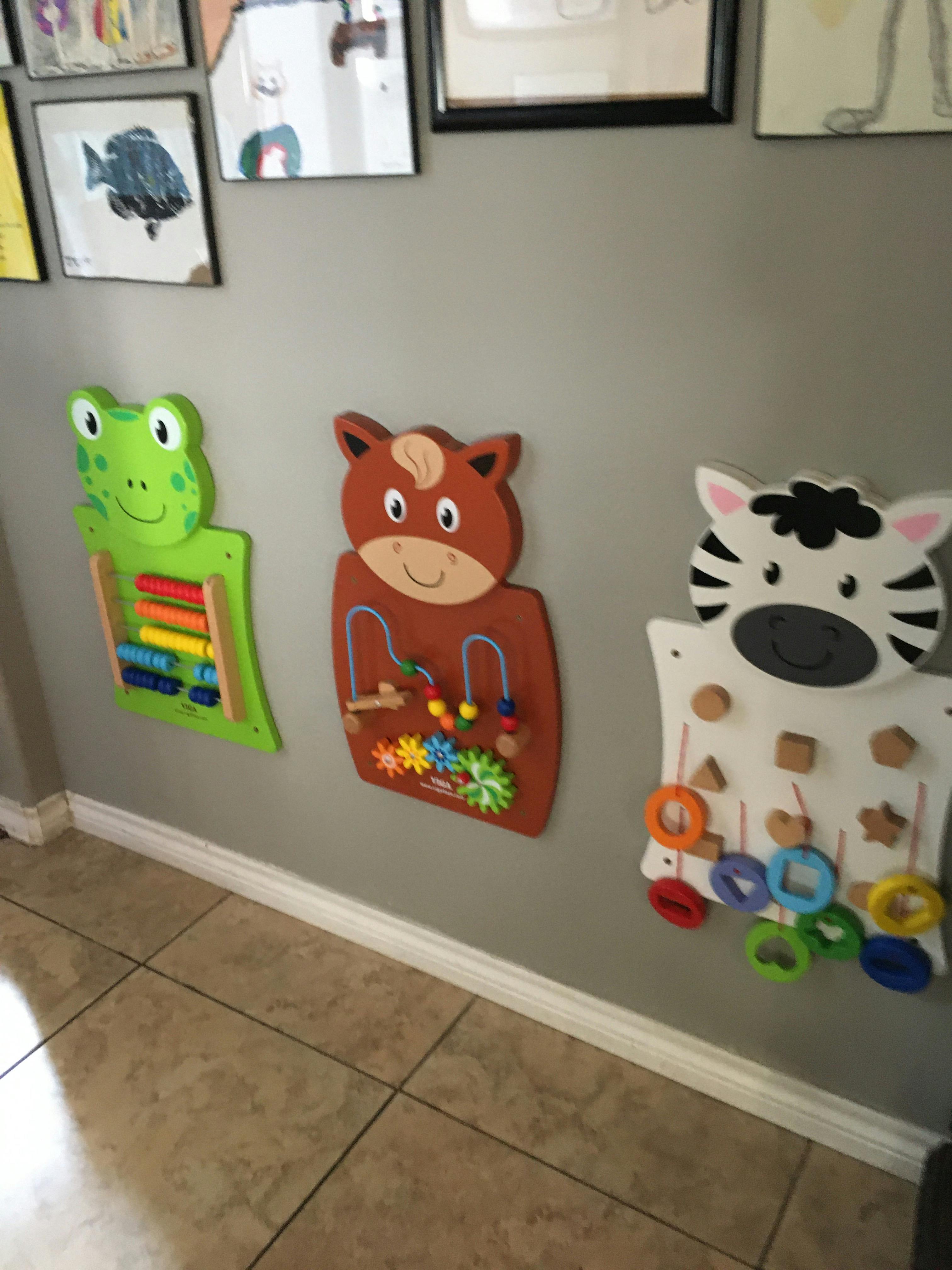 Three wall-mounted activity boards shaped like a frog, horse, and zebra