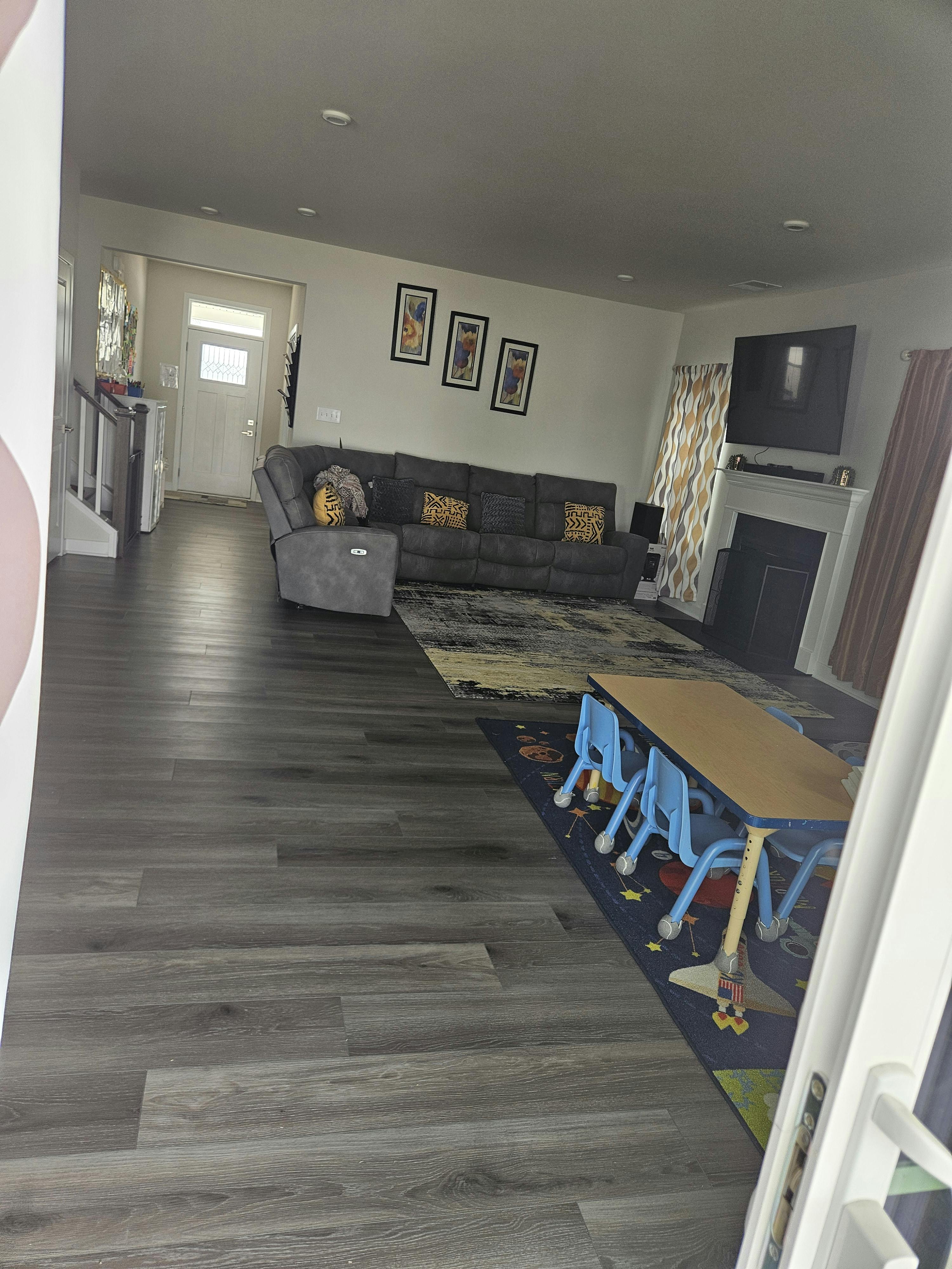 Living room with gray sectional sofa, television, and child's table with blue chairs