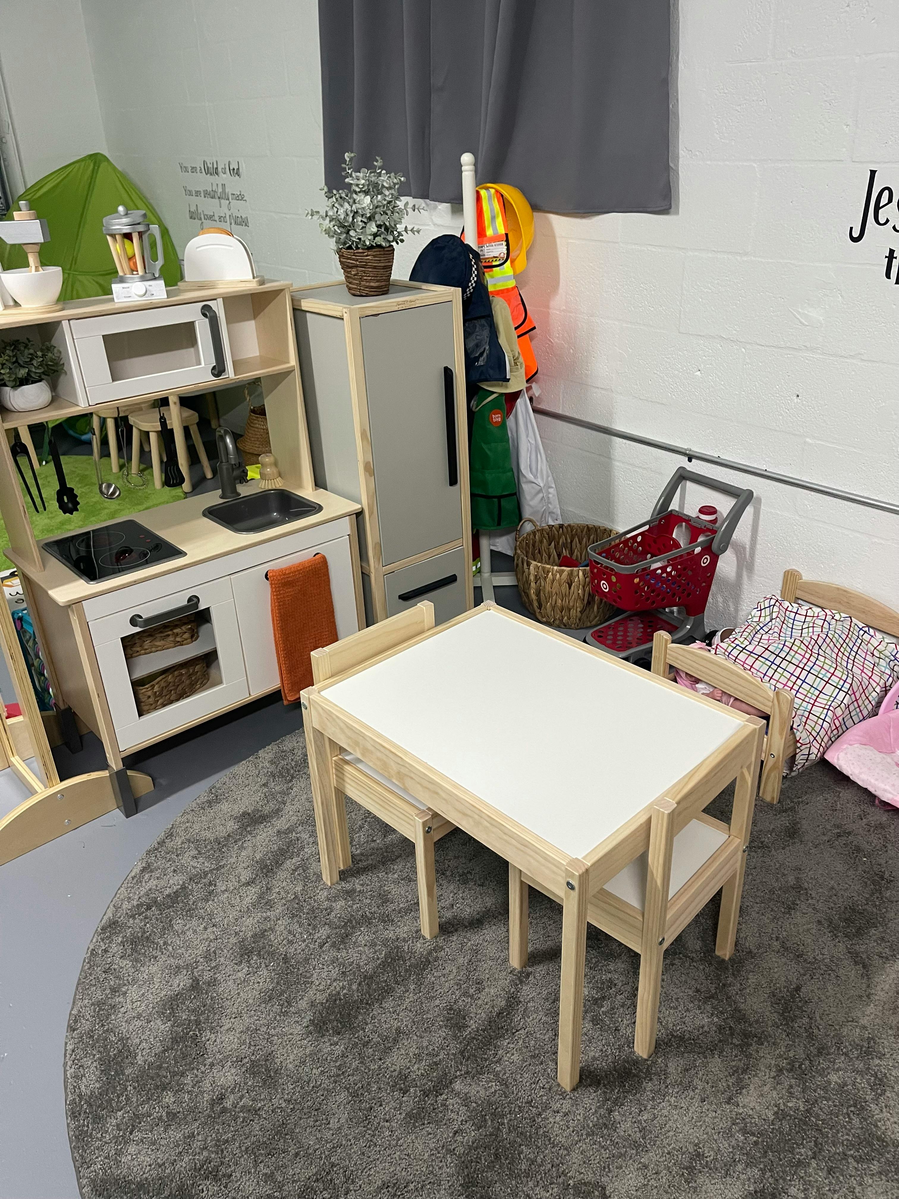 Play kitchen and small table with chairs in a room