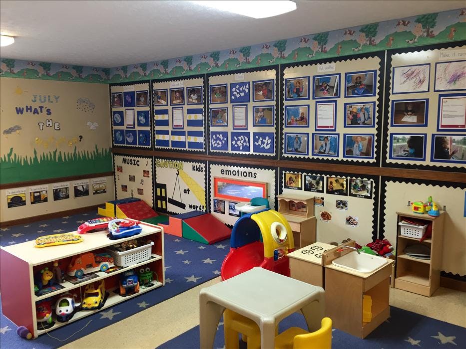 Classroom filled with toys, child-sized furniture, and decorated walls