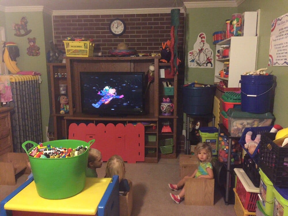 Children playing in a room with a television and toys