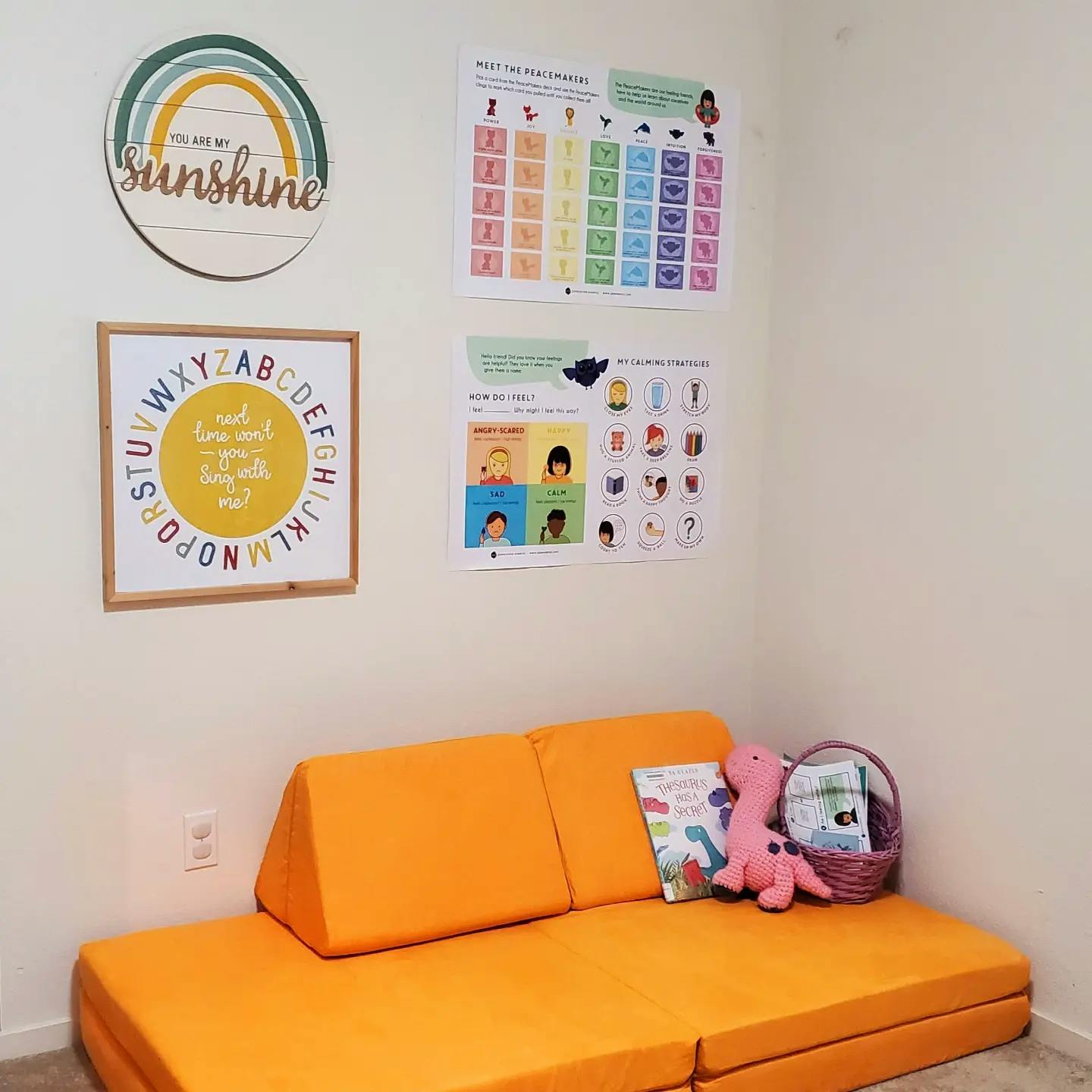 Orange modular sofa with educational posters on the wall
