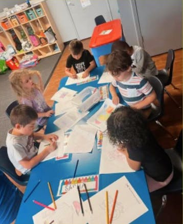 Children drawing at a table in a classroom