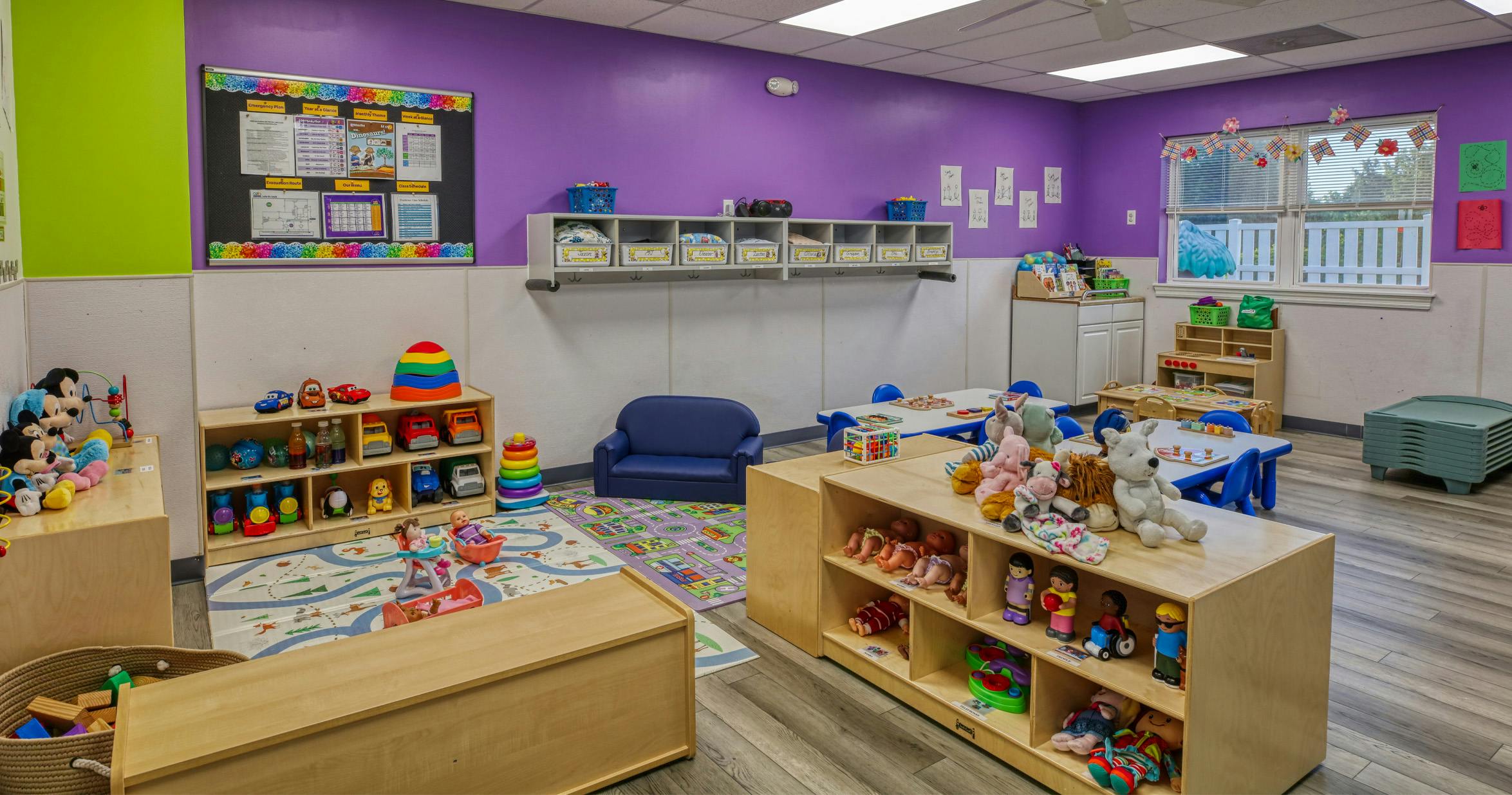 Children's classroom with toys, small tables, and bulletin board