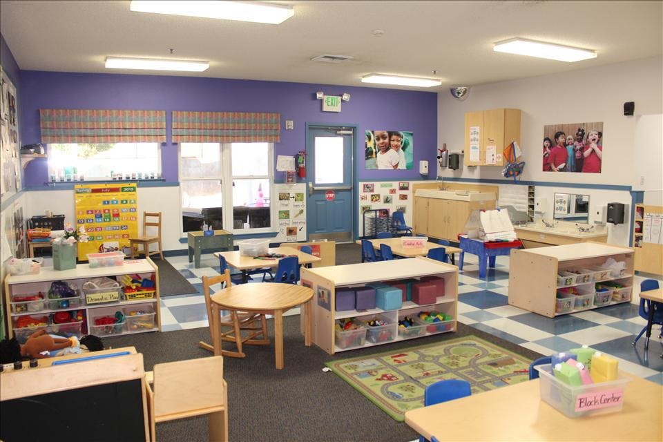 Classroom with small tables, chairs, and play areas