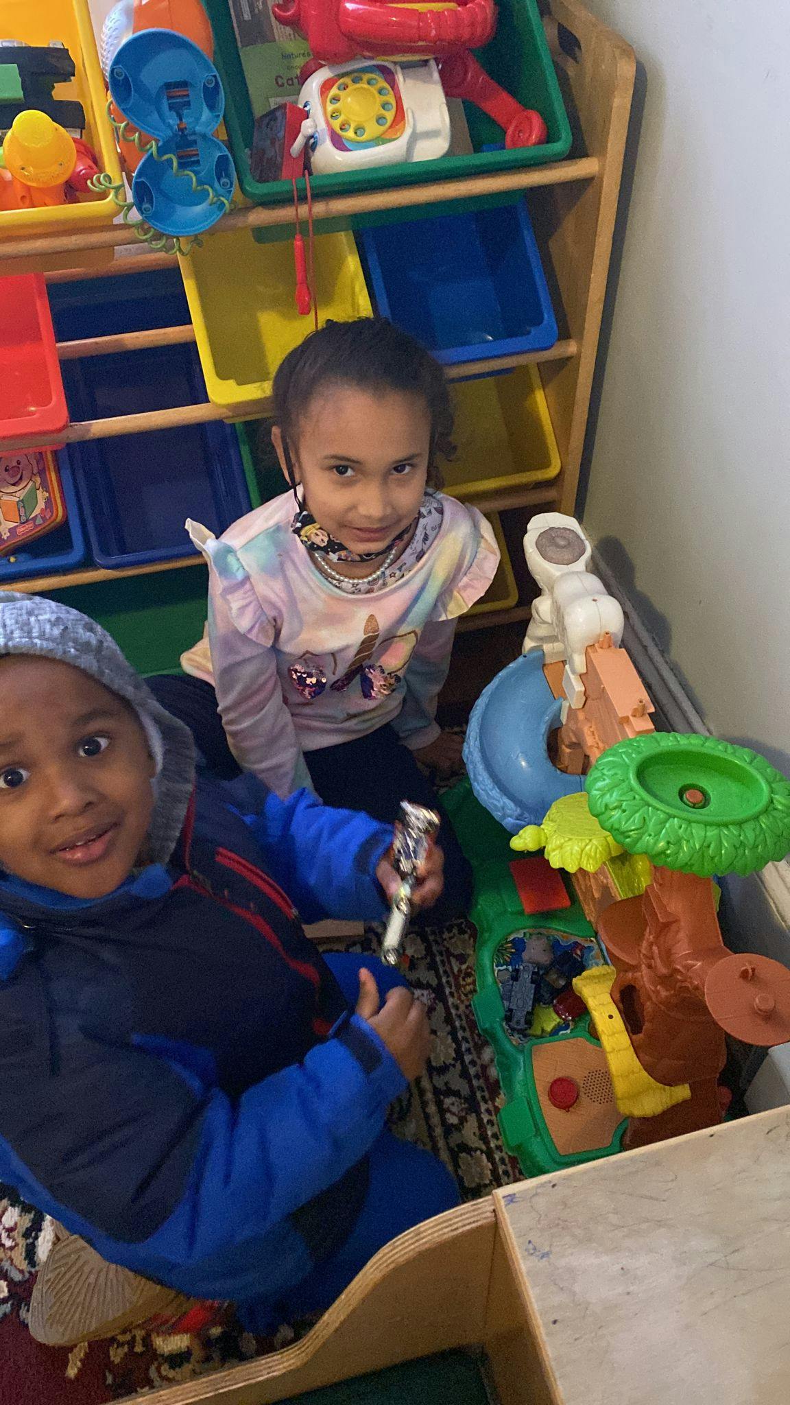Two children playing with toys on the floor