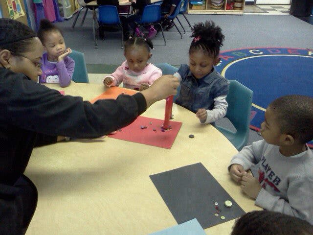 Adult and children doing an art activity at a table