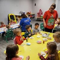 Adults and children seated at tables in a room