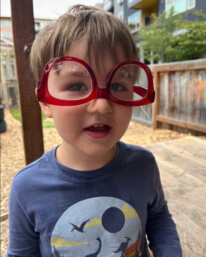 Child wearing oversized red glasses