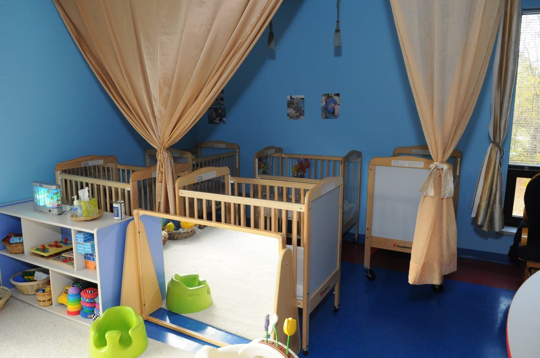 Nursery room with multiple cribs and play items