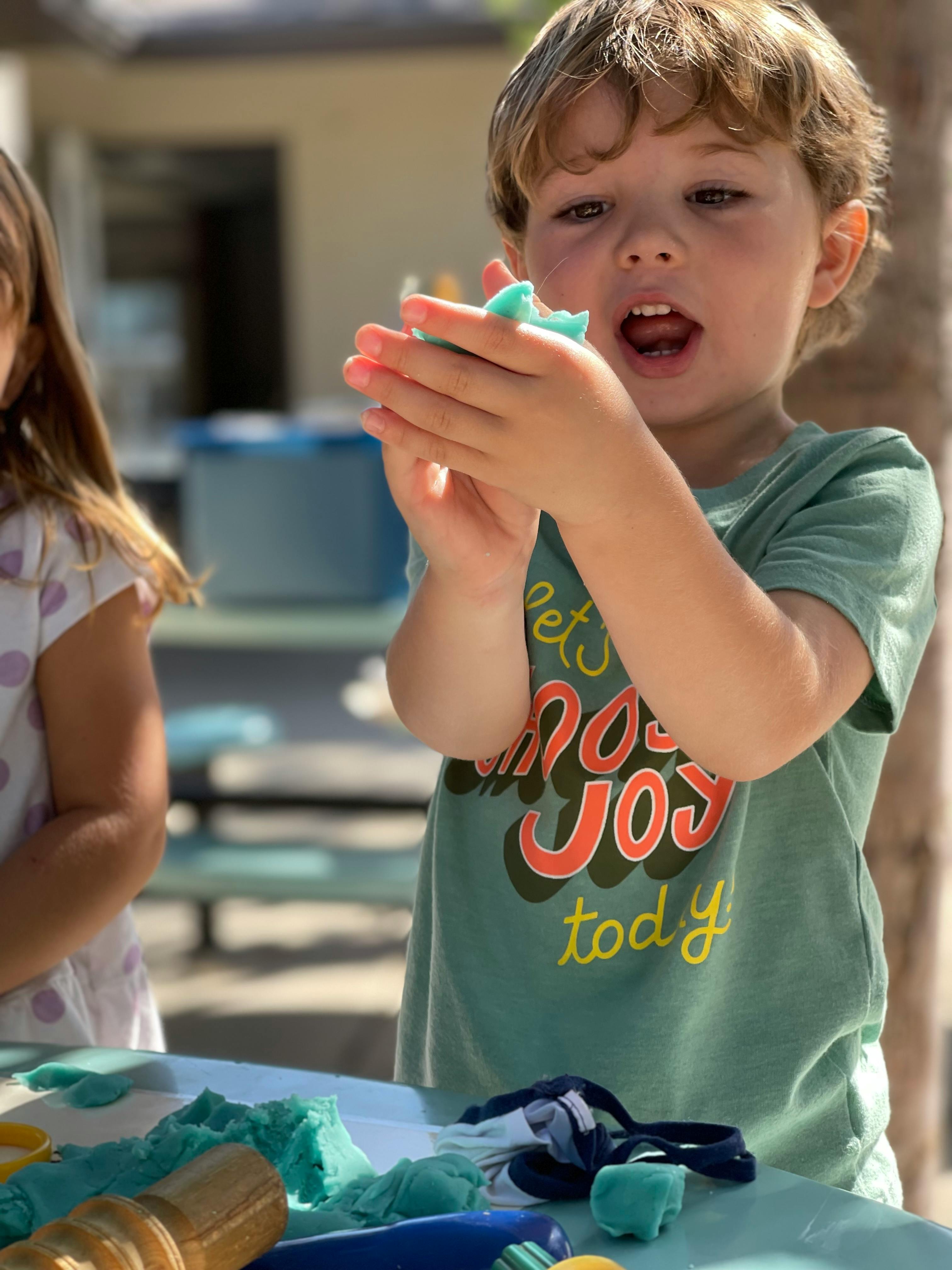 Child playing with blue kinetic sand