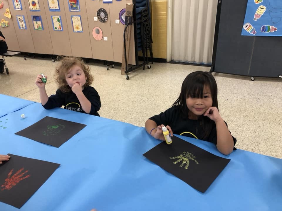 Two children at a table with art supplies