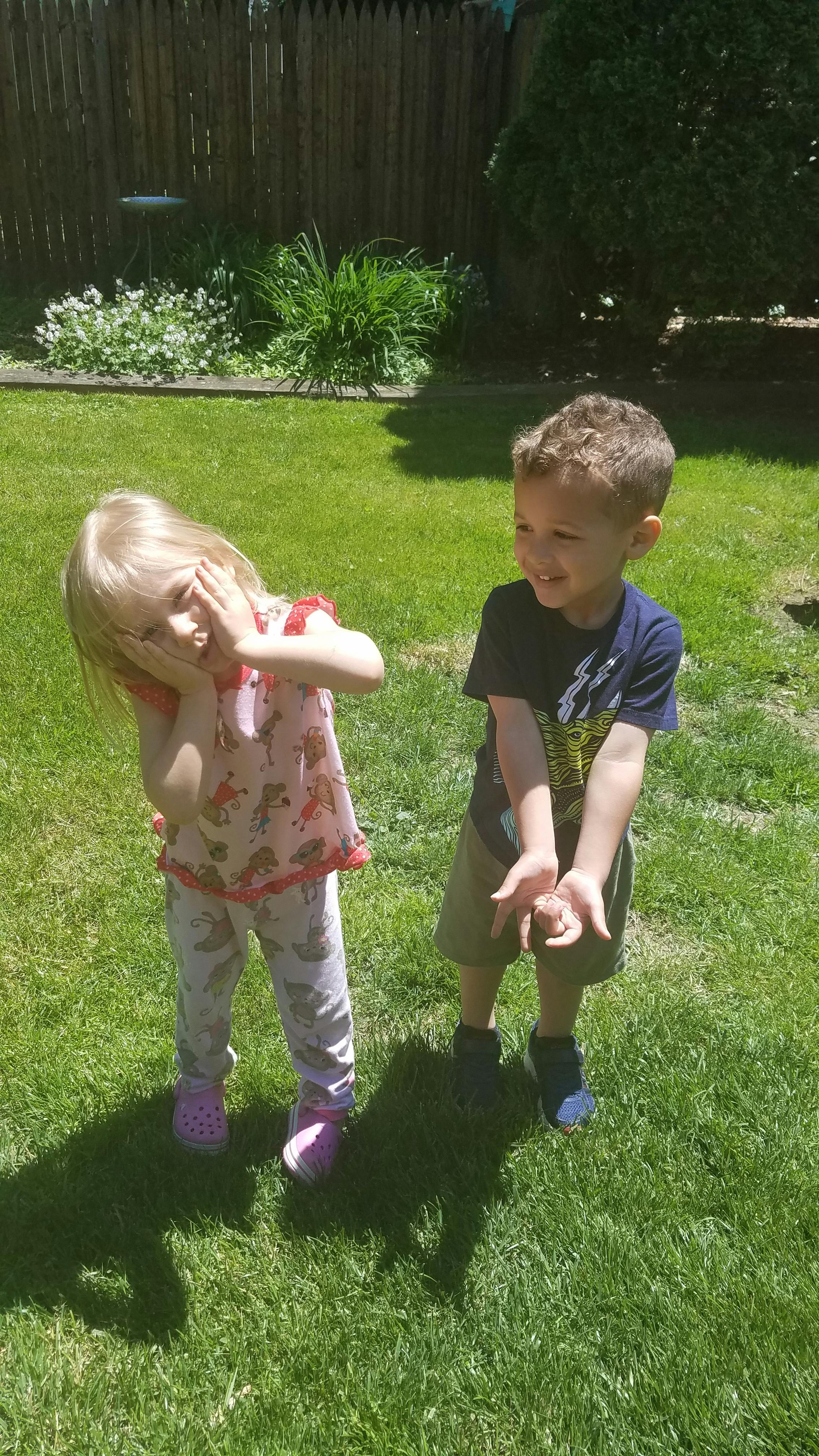 Two children playing in grass