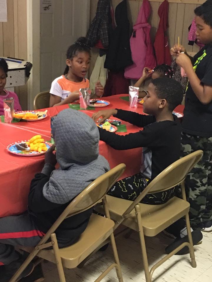 Children sitting at a table with food