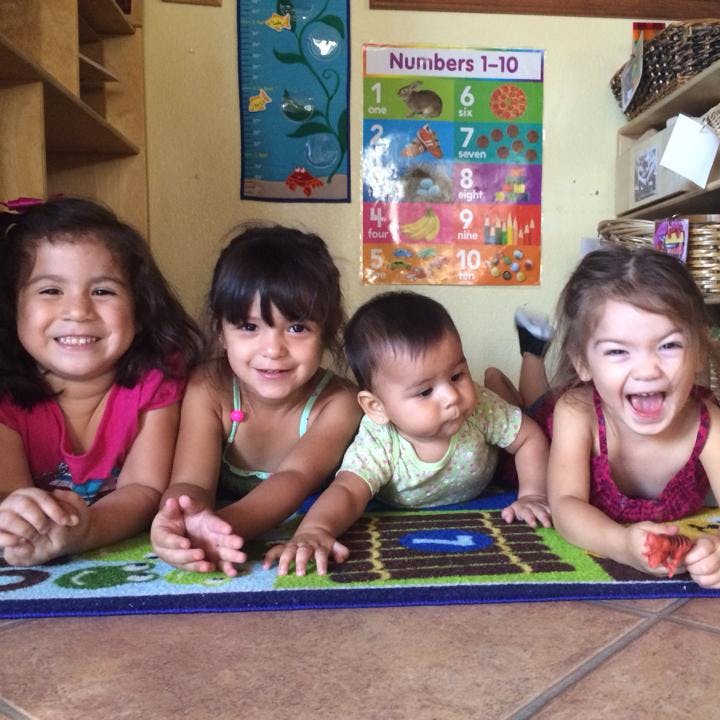Four children lying on a mat