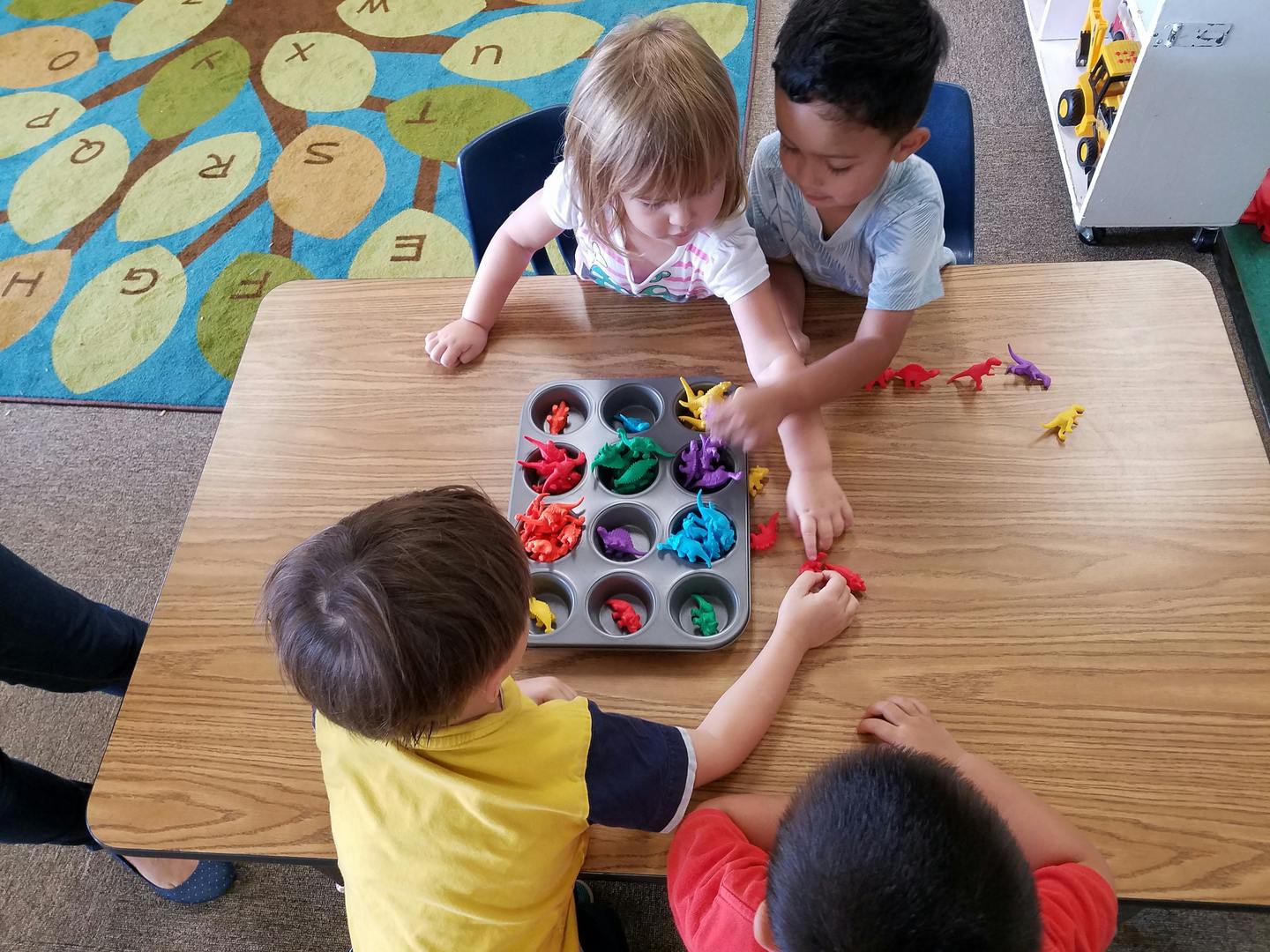 Children playing with colorful sorting toys at a table