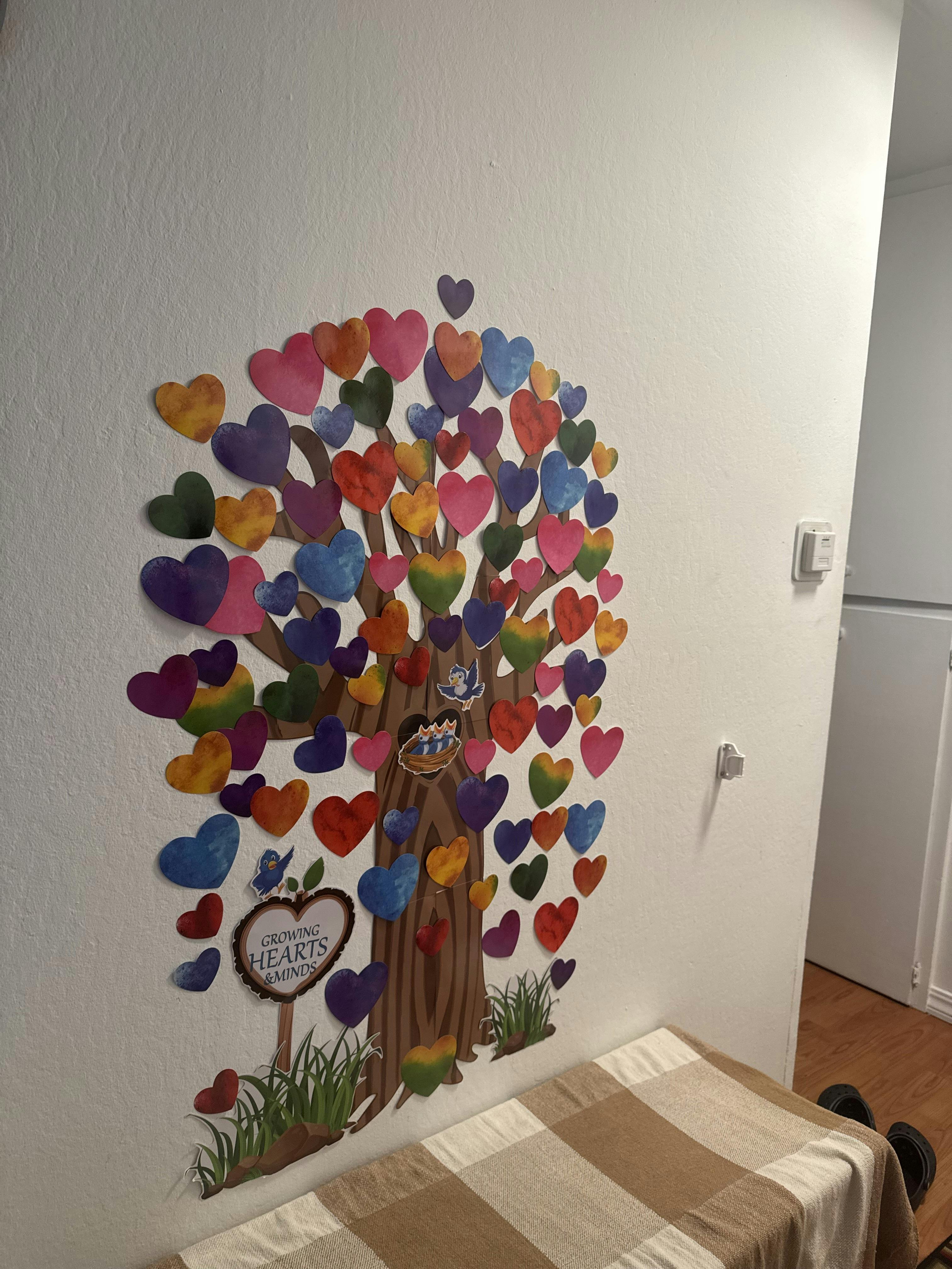 Tree with colorful heart-shaped leaves on a wall