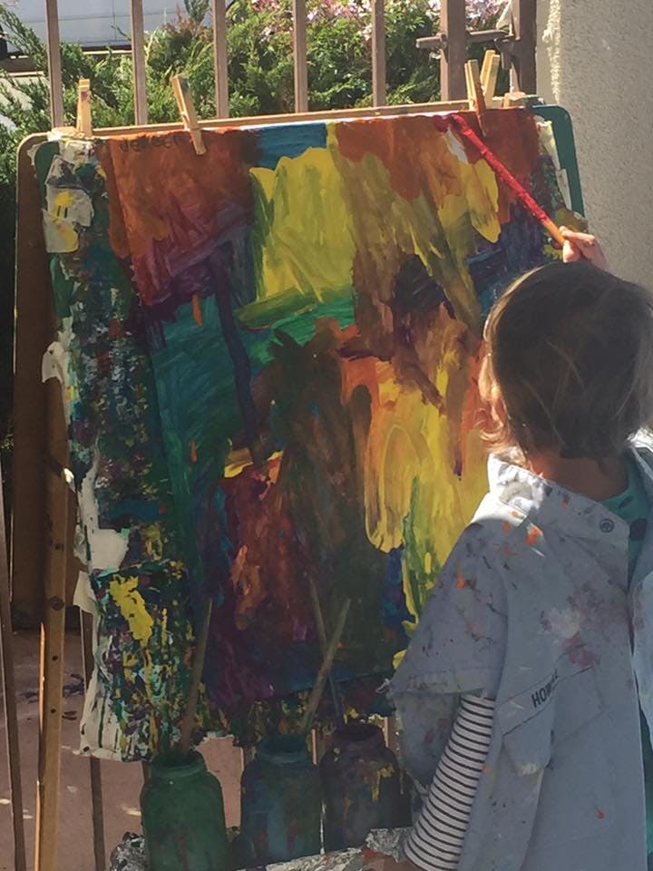 Child painting on an easel with a brush
