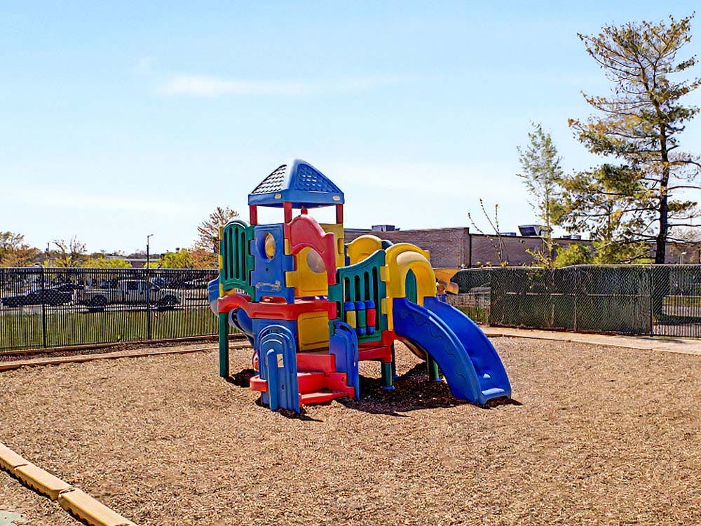 Colorful playground with slides and a climbing structure on wood chips