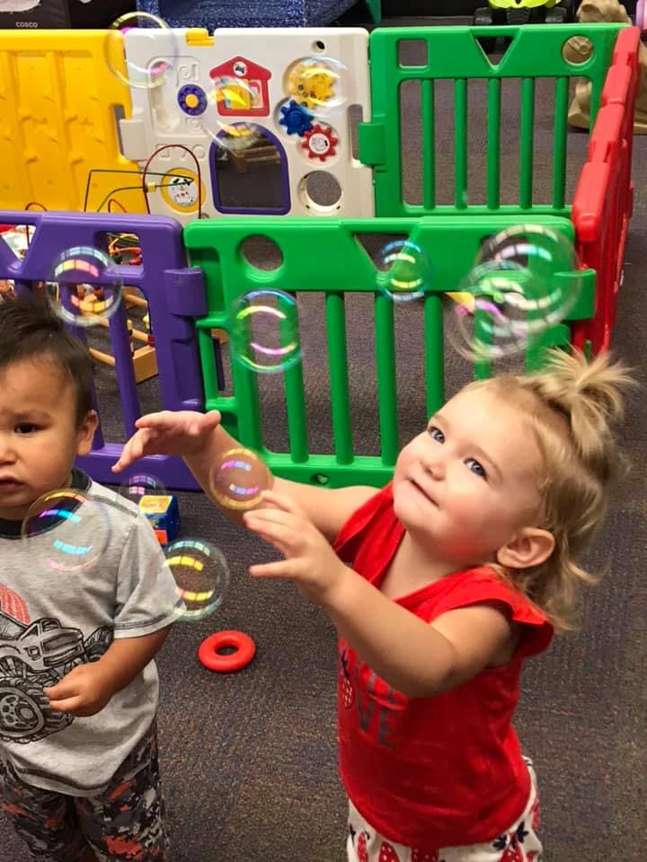 Two children playing with bubbles