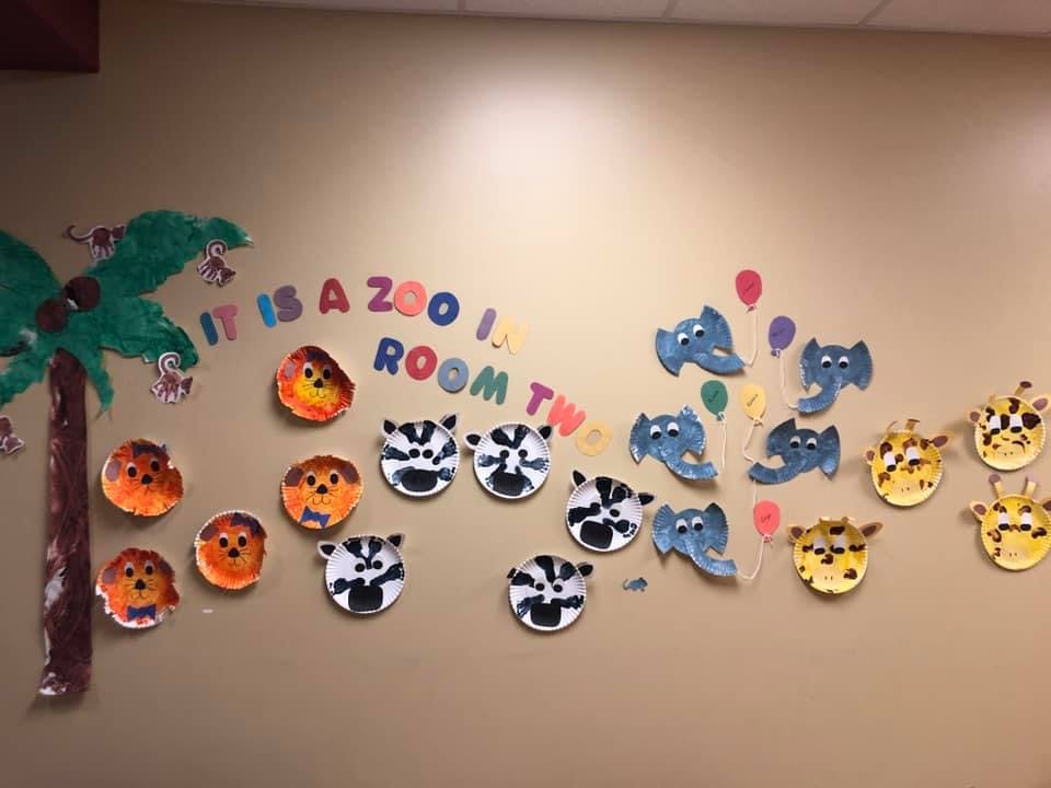 Wall decorated with paper animal faces and text "It is a zoo! Room Two"