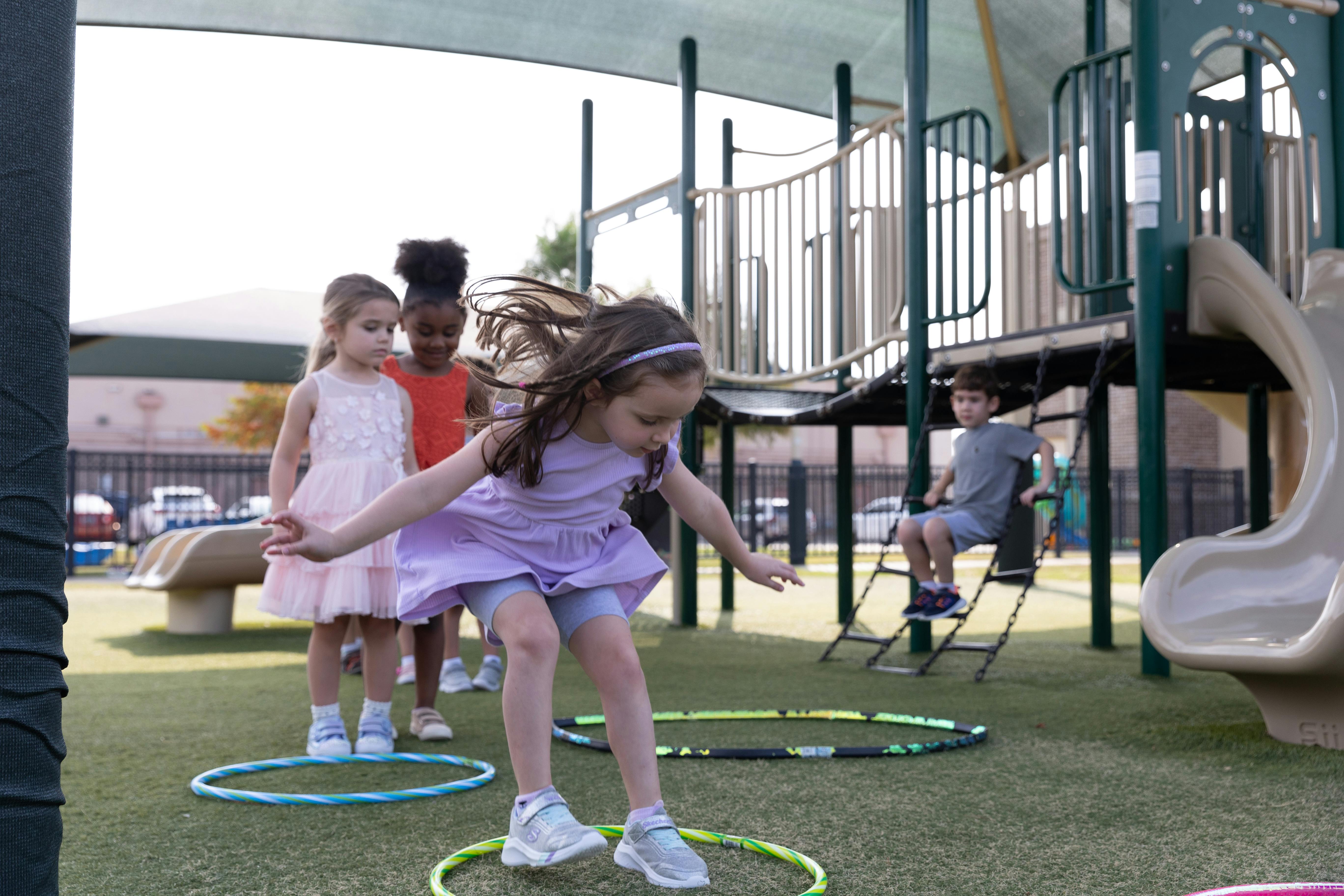 Children playing with hula hoops on a playground