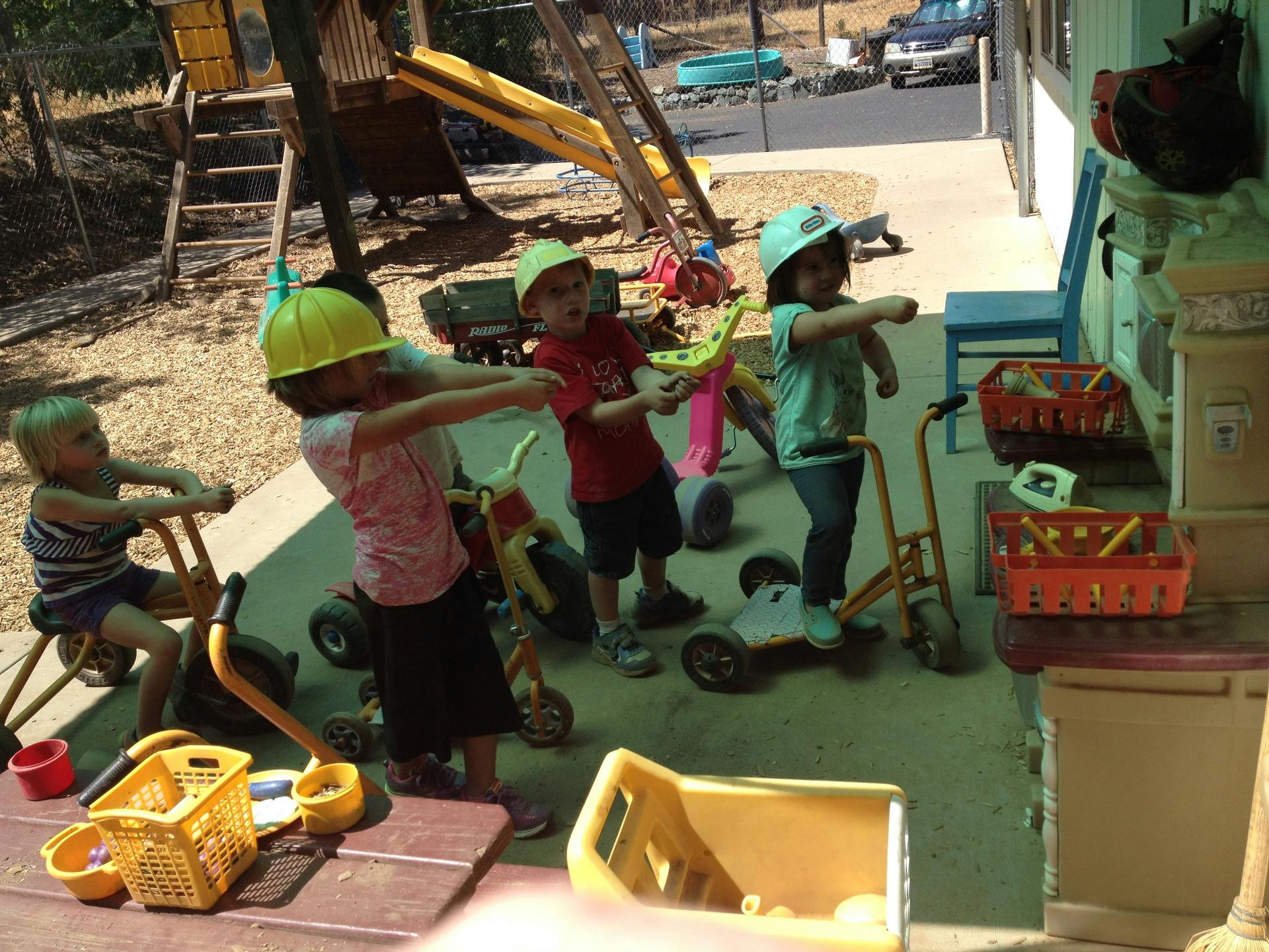 Children playing with toys and riding tricycles outdoors