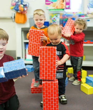 Children playing with large red and blue block toys