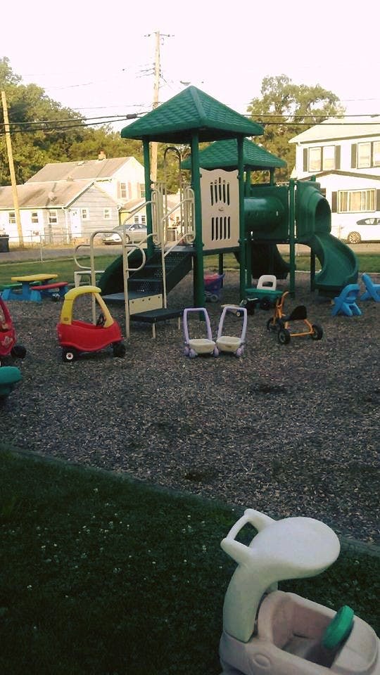 Playground with green play structure and ride-on toys