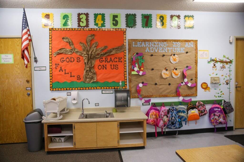 Classroom with sink, bulletin boards, and backpacks hanging on a wall