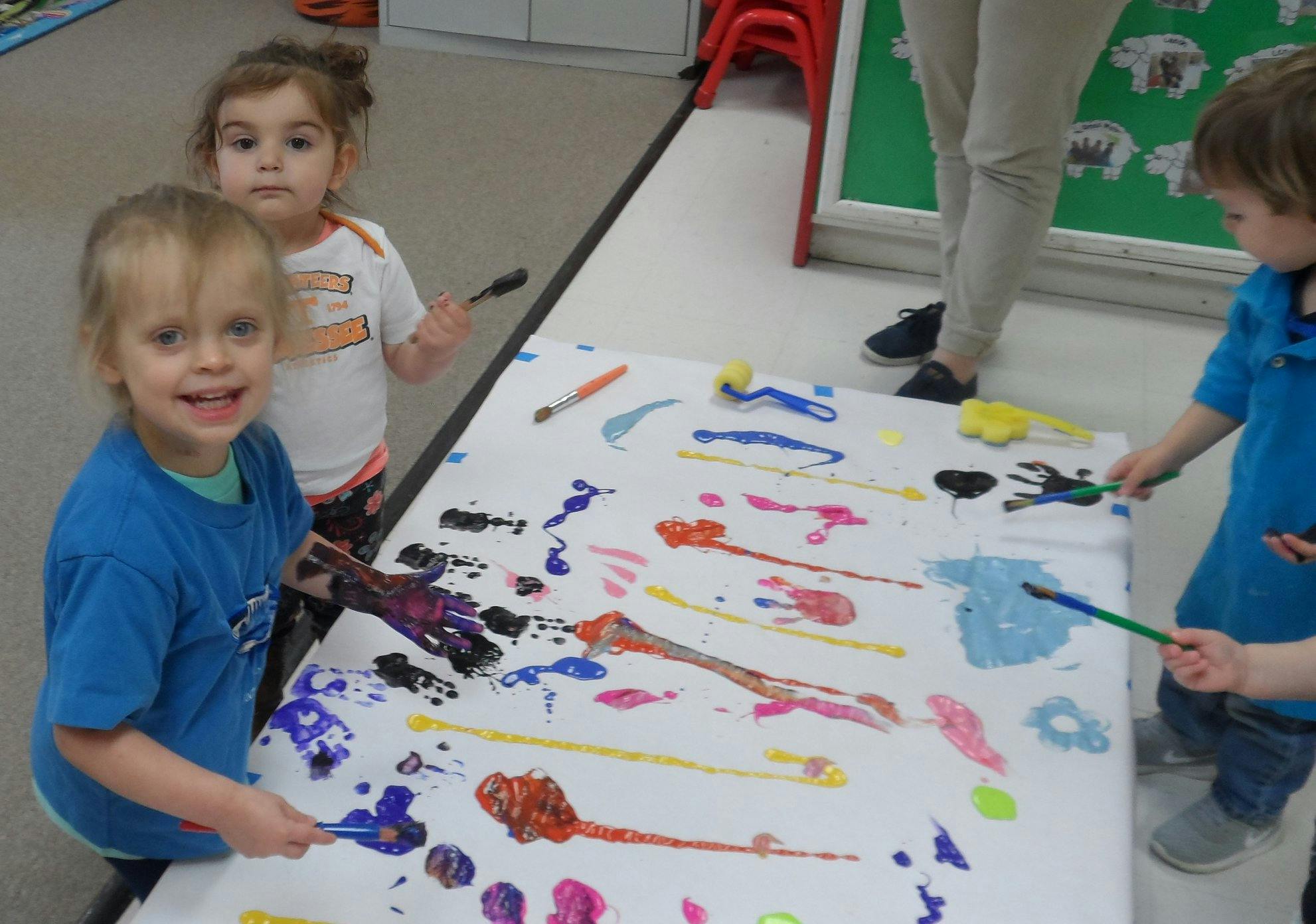 Children painting on a large sheet of paper