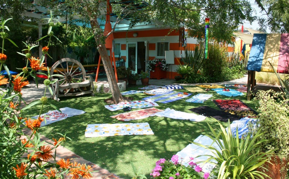 Towels laid out on a grassy lawn with a building in the background