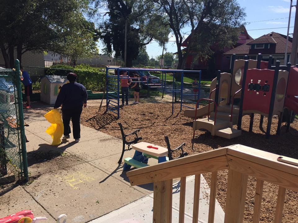 Person walking on a sidewalk next to a playground