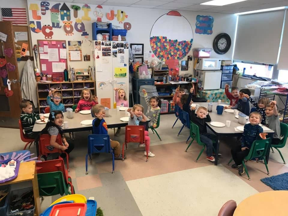 Children sitting at tables in a classroom
