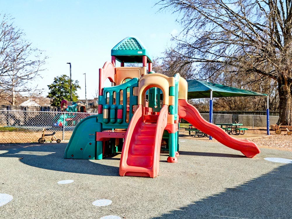 Colorful playground with slides, climbing structures, and covered picnic tables