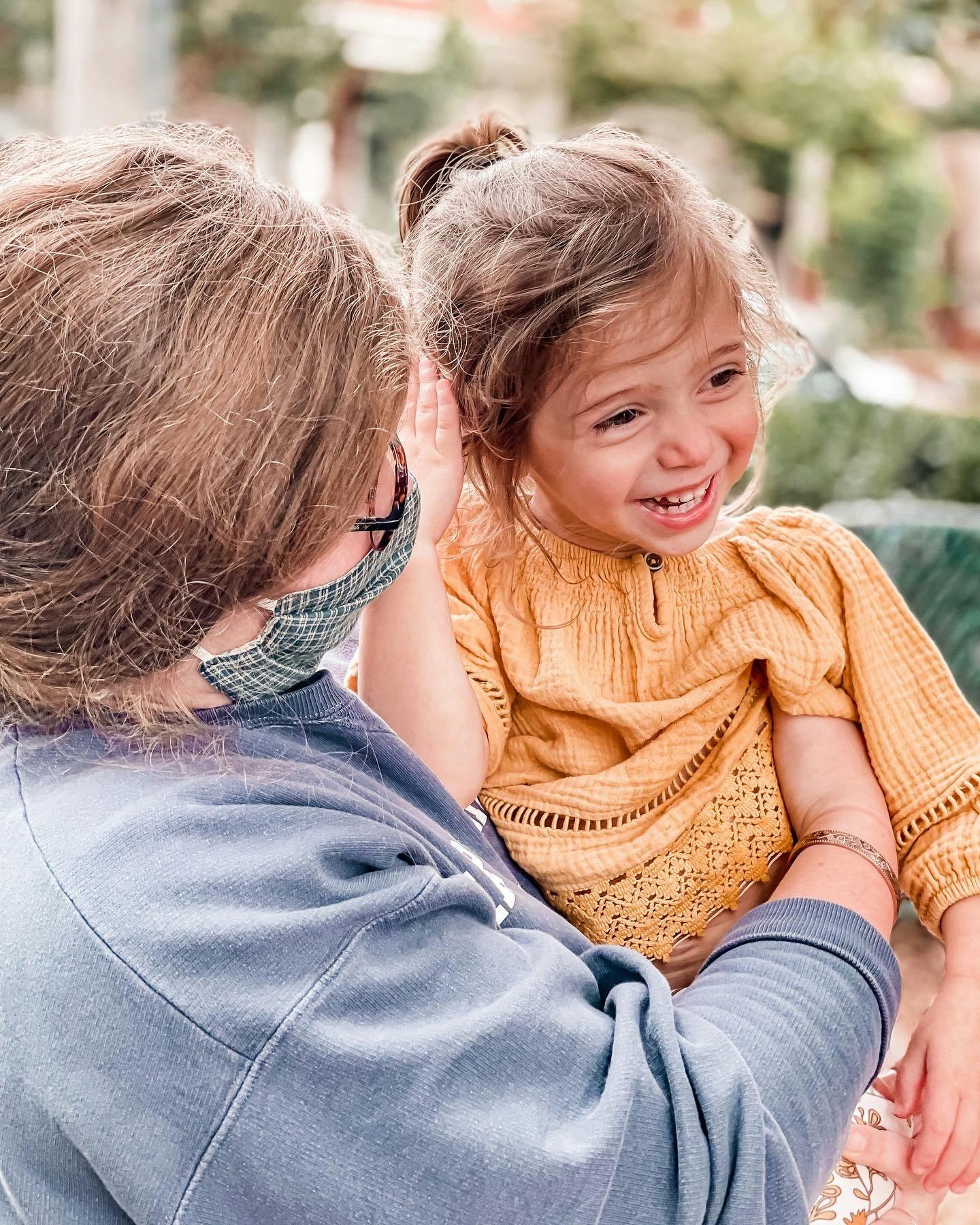Person in mask holding a child