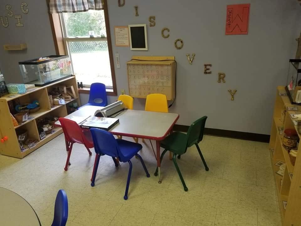 Classroom with small table and chairs, shelves, and window