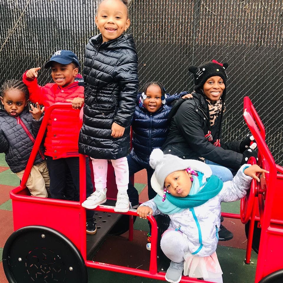 Adult and children on a red playground structure