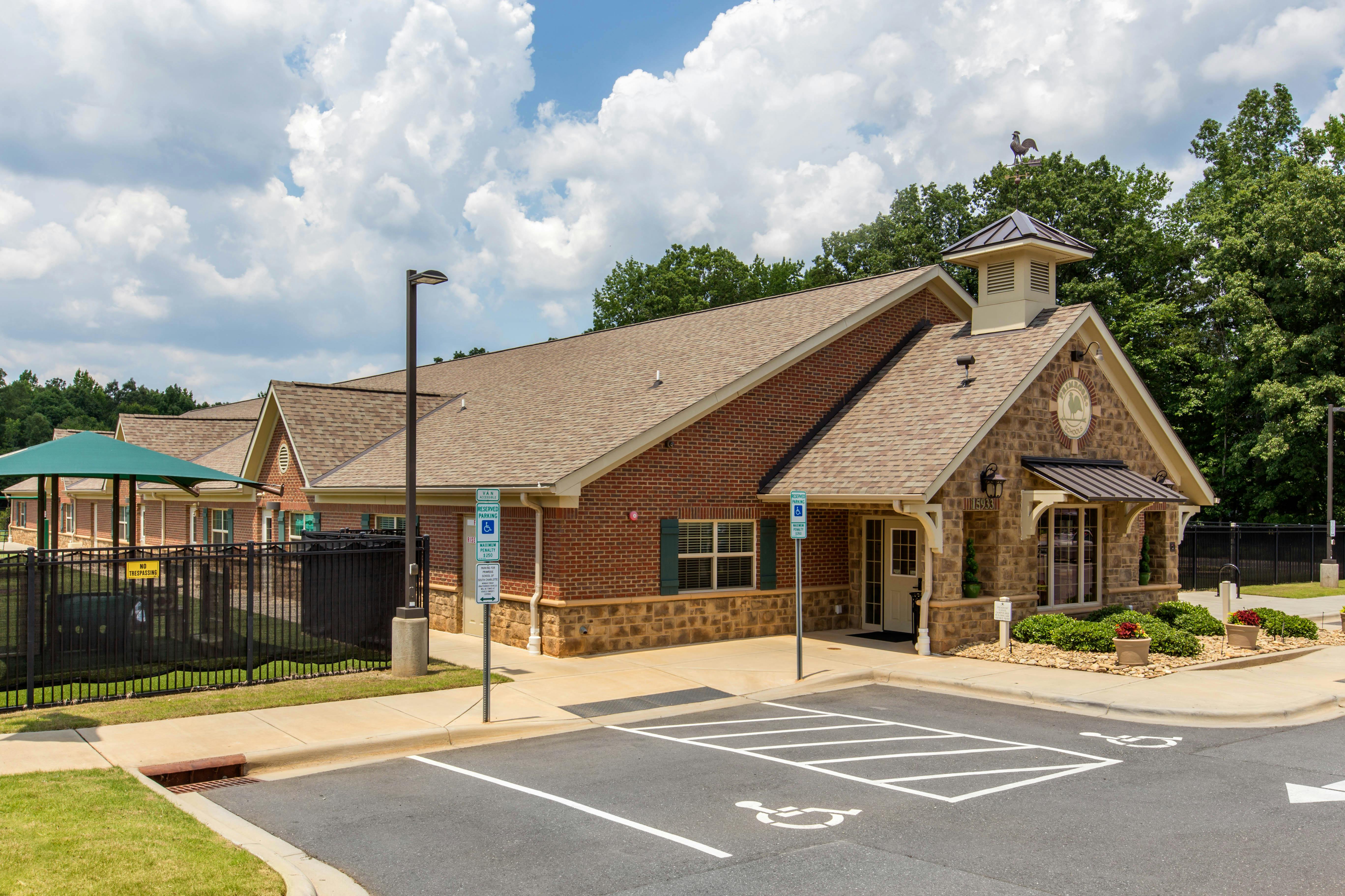 red brick building with stone accents and a parking lot with a handicap space
