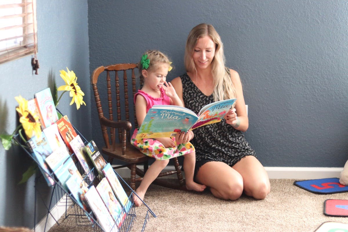 Person and child reading a book together