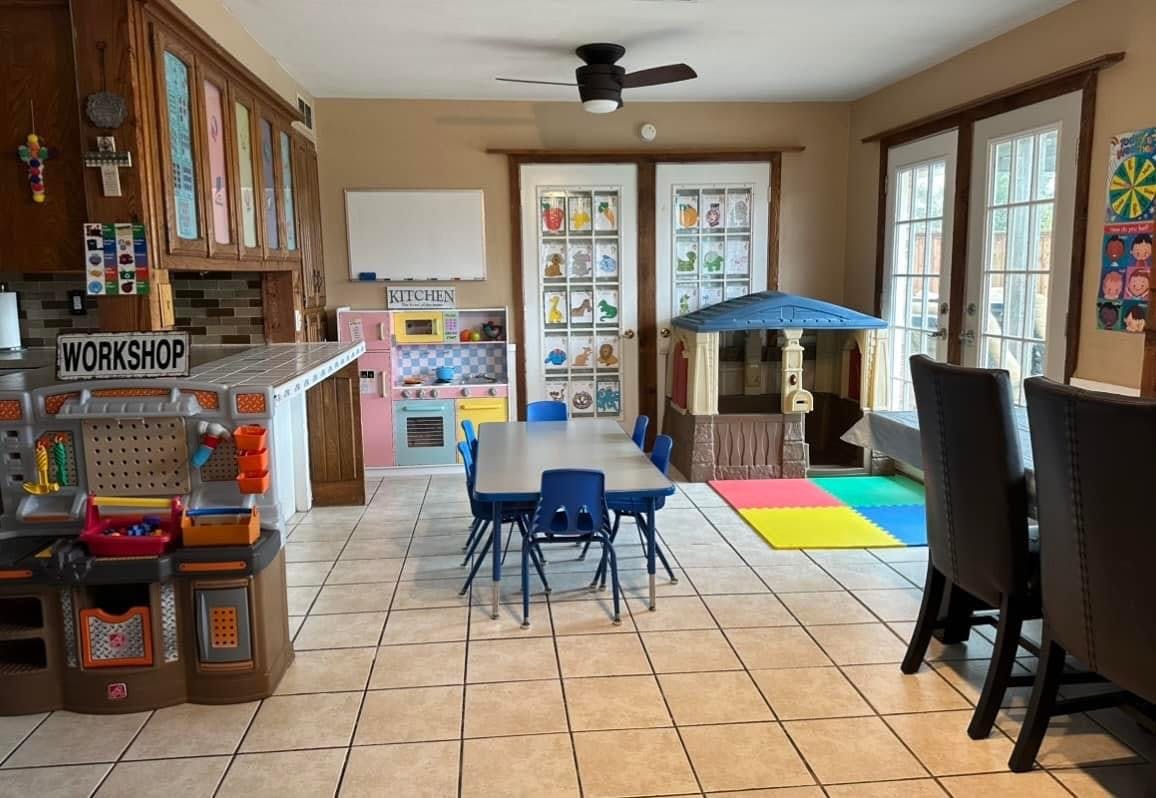 Playroom with a table and chairs, play kitchen, and playhouse