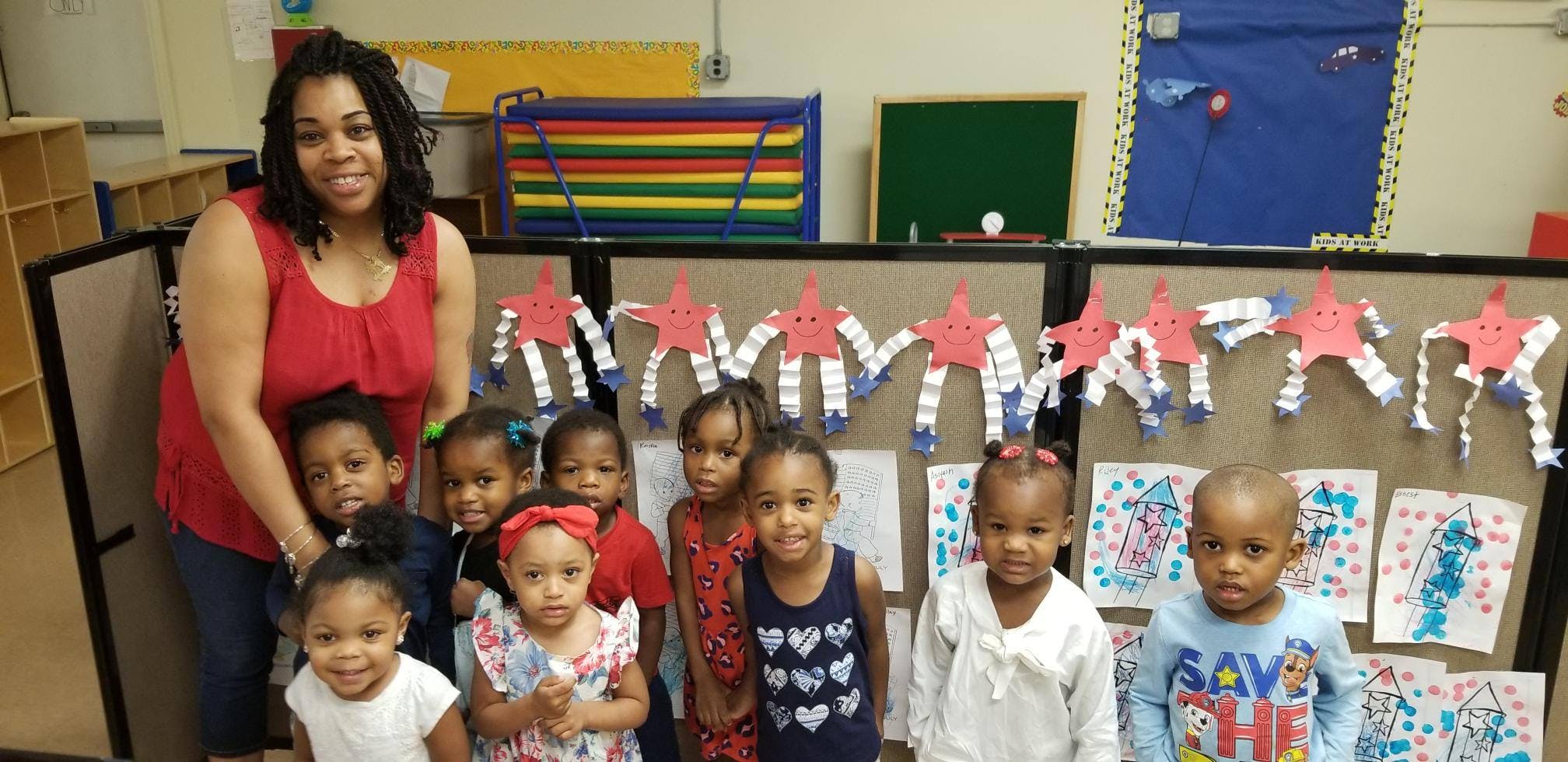 Person and group of children posing in a classroom