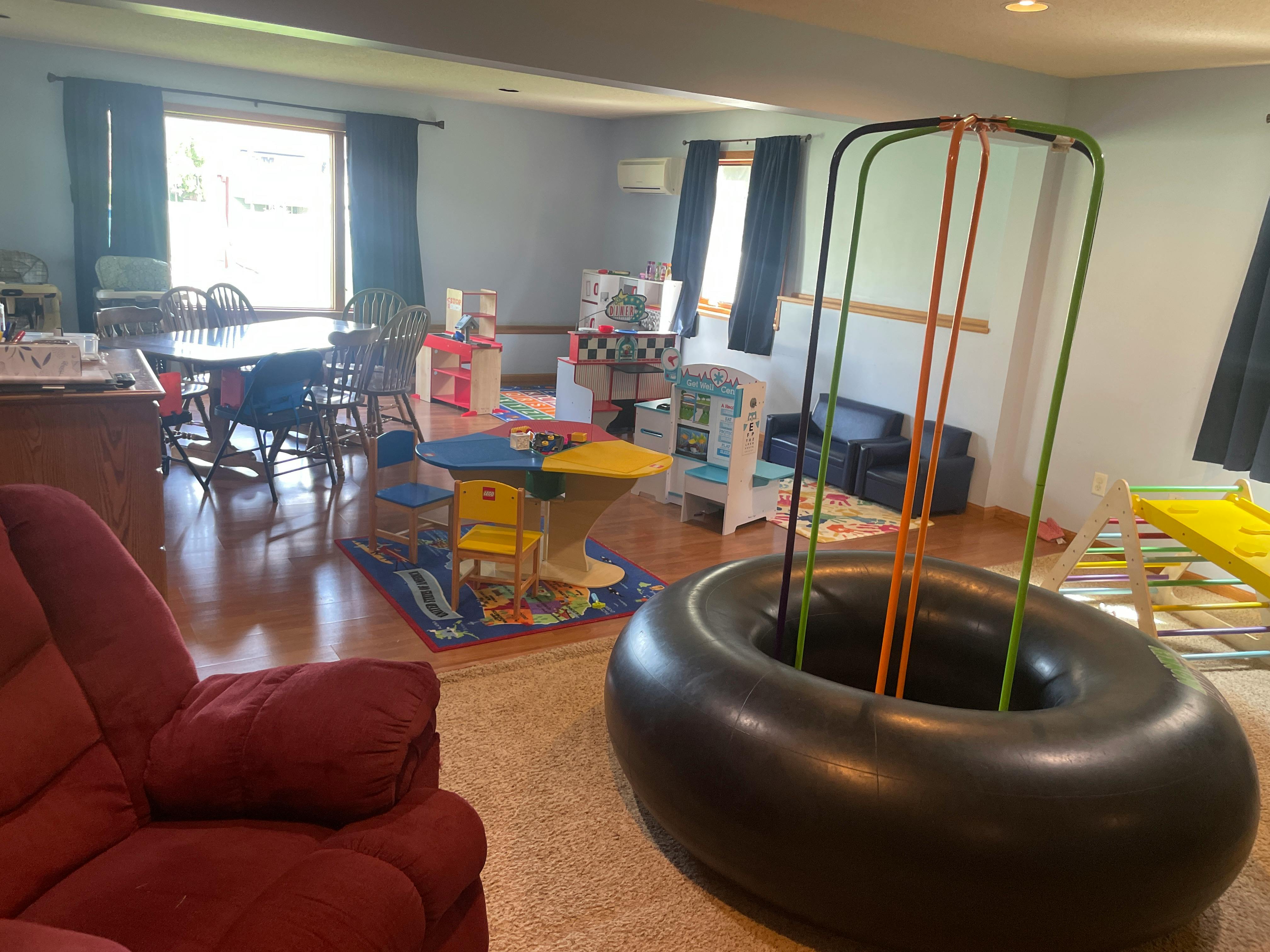 Indoor play area with a large tire swing and children's furniture