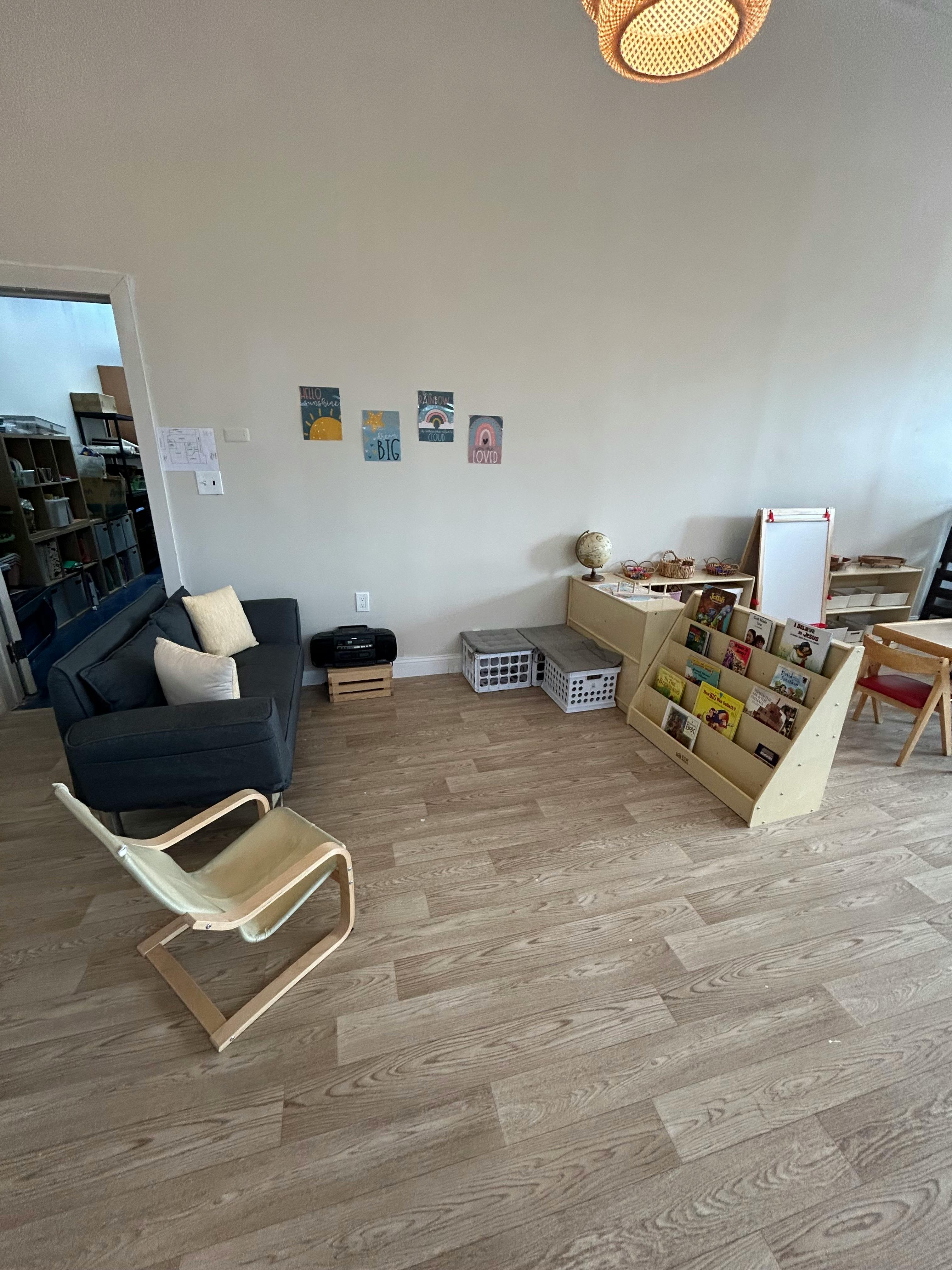 Room with a couch, chair, and book display
