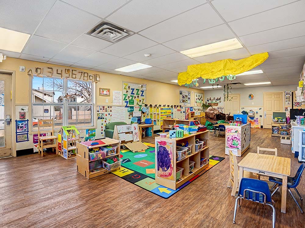 Empty colorful children's classroom with small tables and chairs