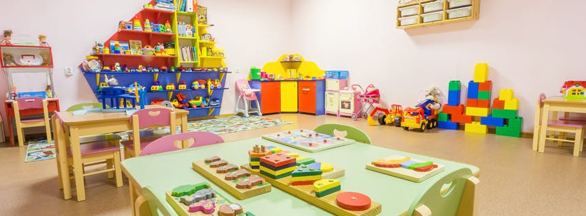 Playroom with tables, chairs, and various toys
