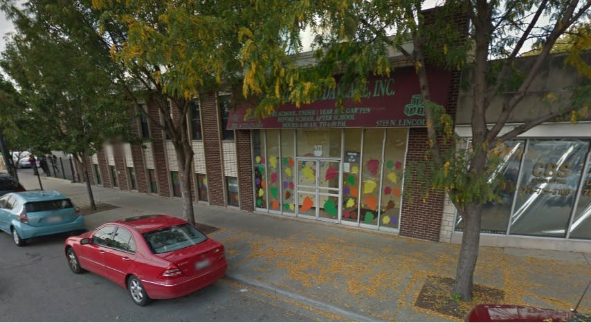 Street view of a building with colorful window decorations and parked cars