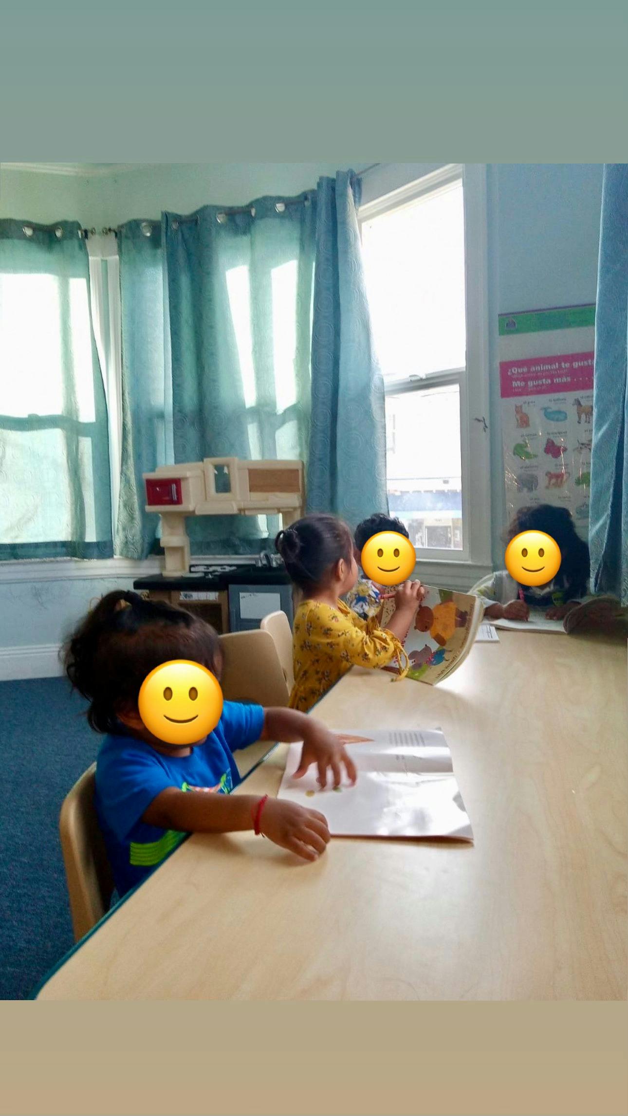 Three children sitting at a table in a classroom
