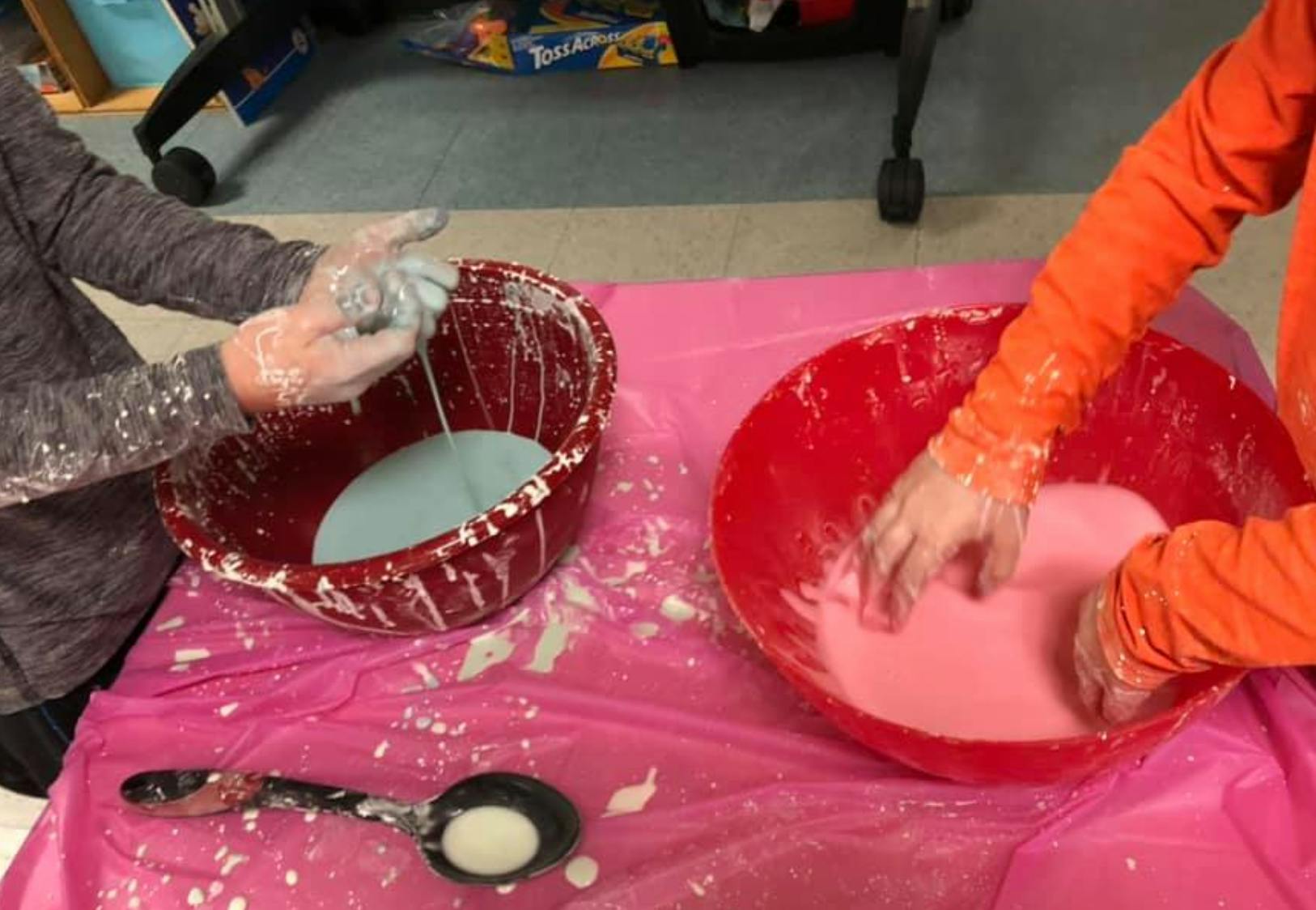 Two people mixing substances in bowls, hands covered in white residue