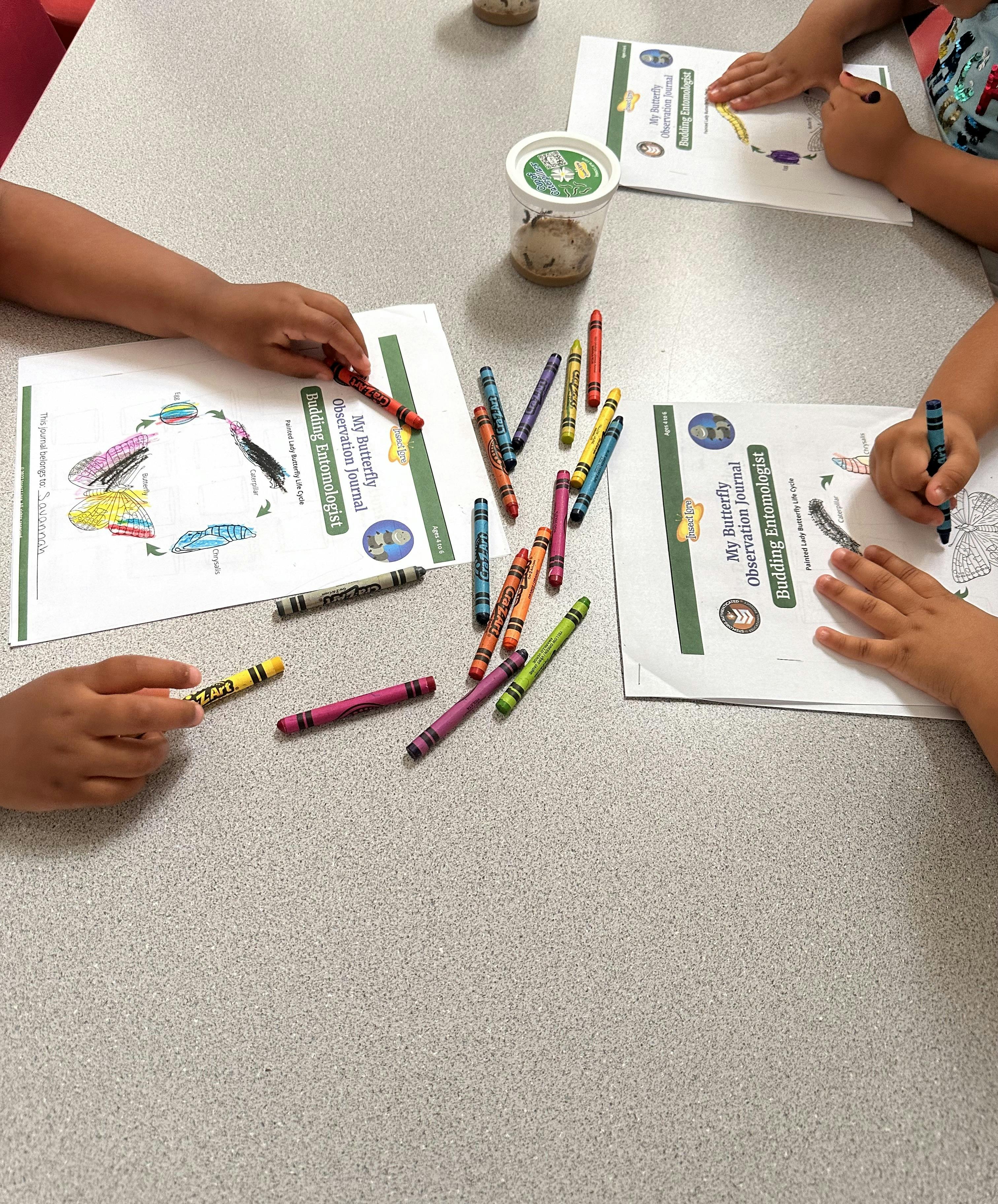 Children coloring at a table with crayons and activity sheets
